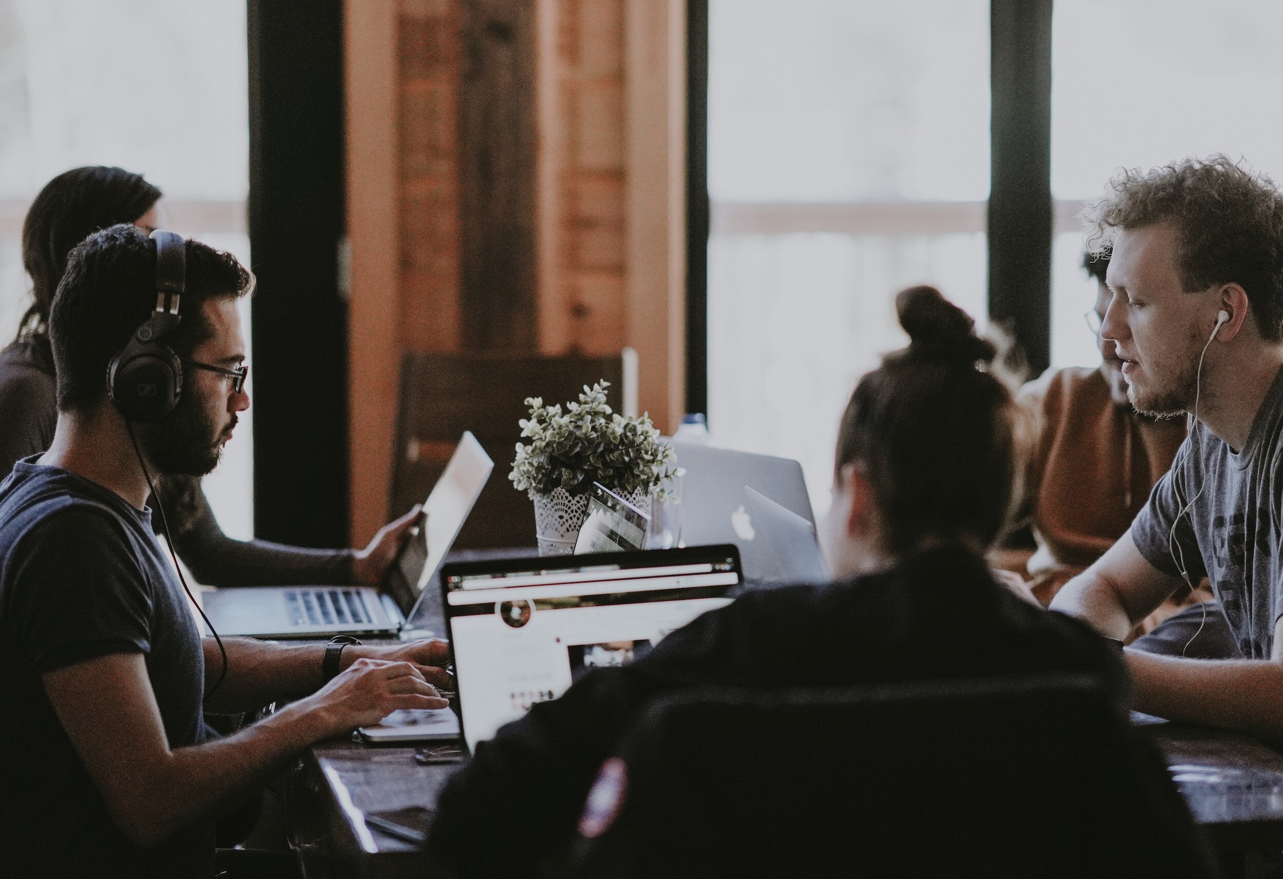 People working on laptops and collaborating in a casual office environment with a relaxed and focused atmosphere.