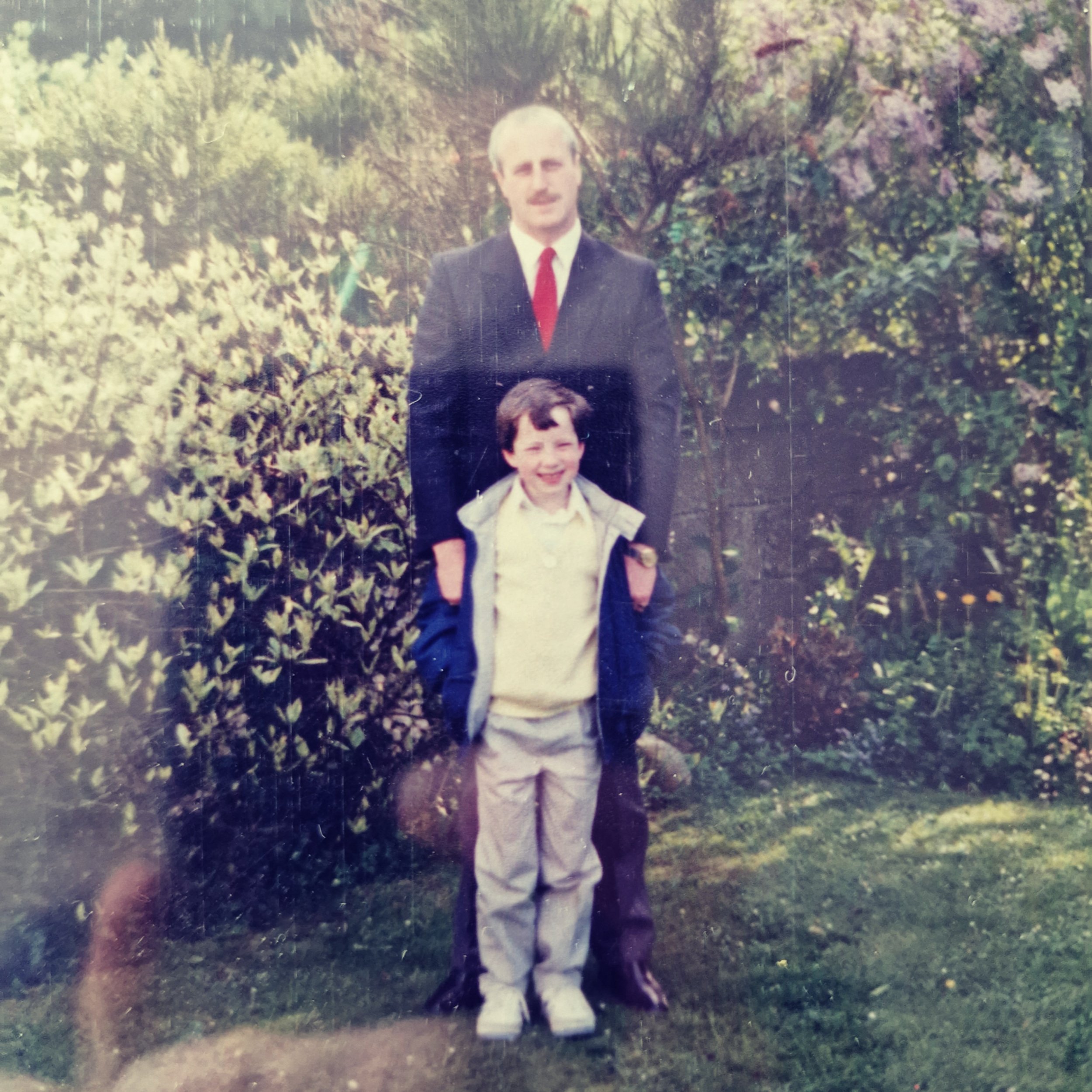 James O'Halloran standing in front of his father wearing a suit