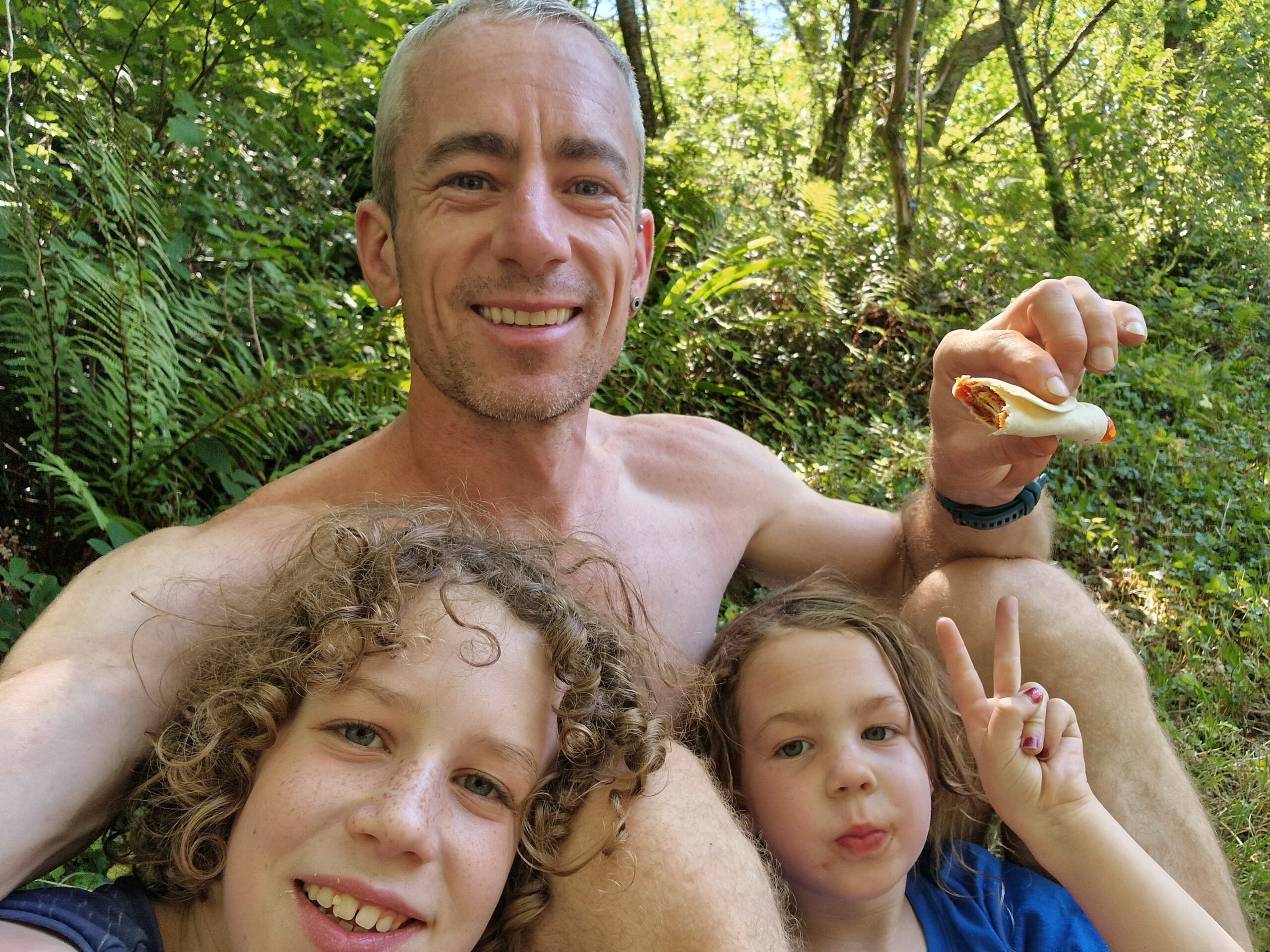 The author eating a roll with his two kids ages 8 and 5 years. All smiling.