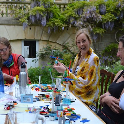 A group of women participating in an outdoor Lego team building workshop.