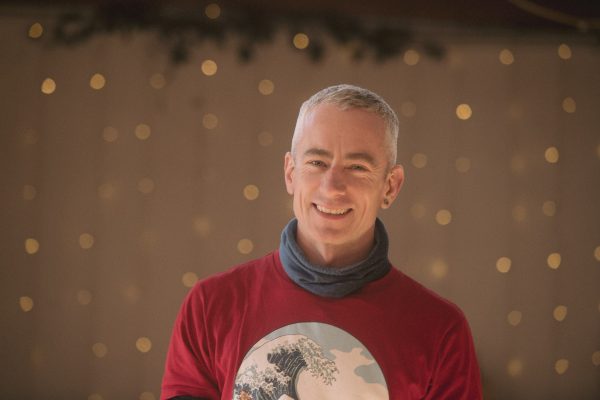 James O'Halloran smiling infront of a blurred background with hanging lights